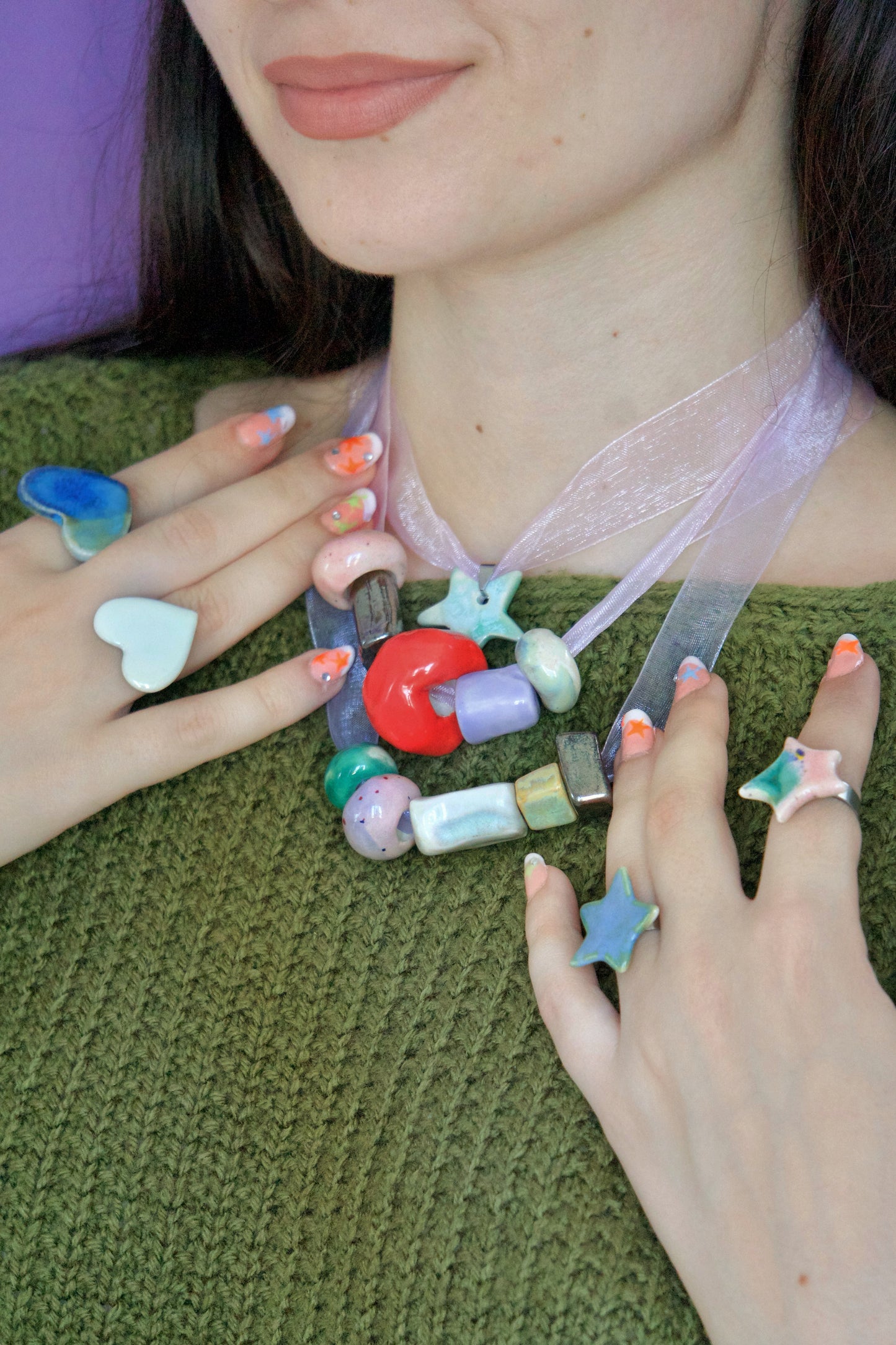 Inel handmade din porțelan, inimă alb perlat lucioasă, purtat împreună cu colier handmade din porțelan cu mărgele colorate și inele în formă de stea – bijuterii artizanale unicat.