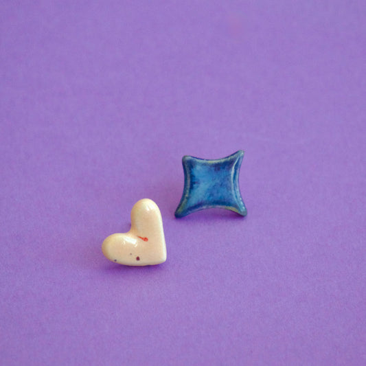 Cercei handmade asimetrici – inimă crem și romb albastru lucios, cu tije hipoalergenice.