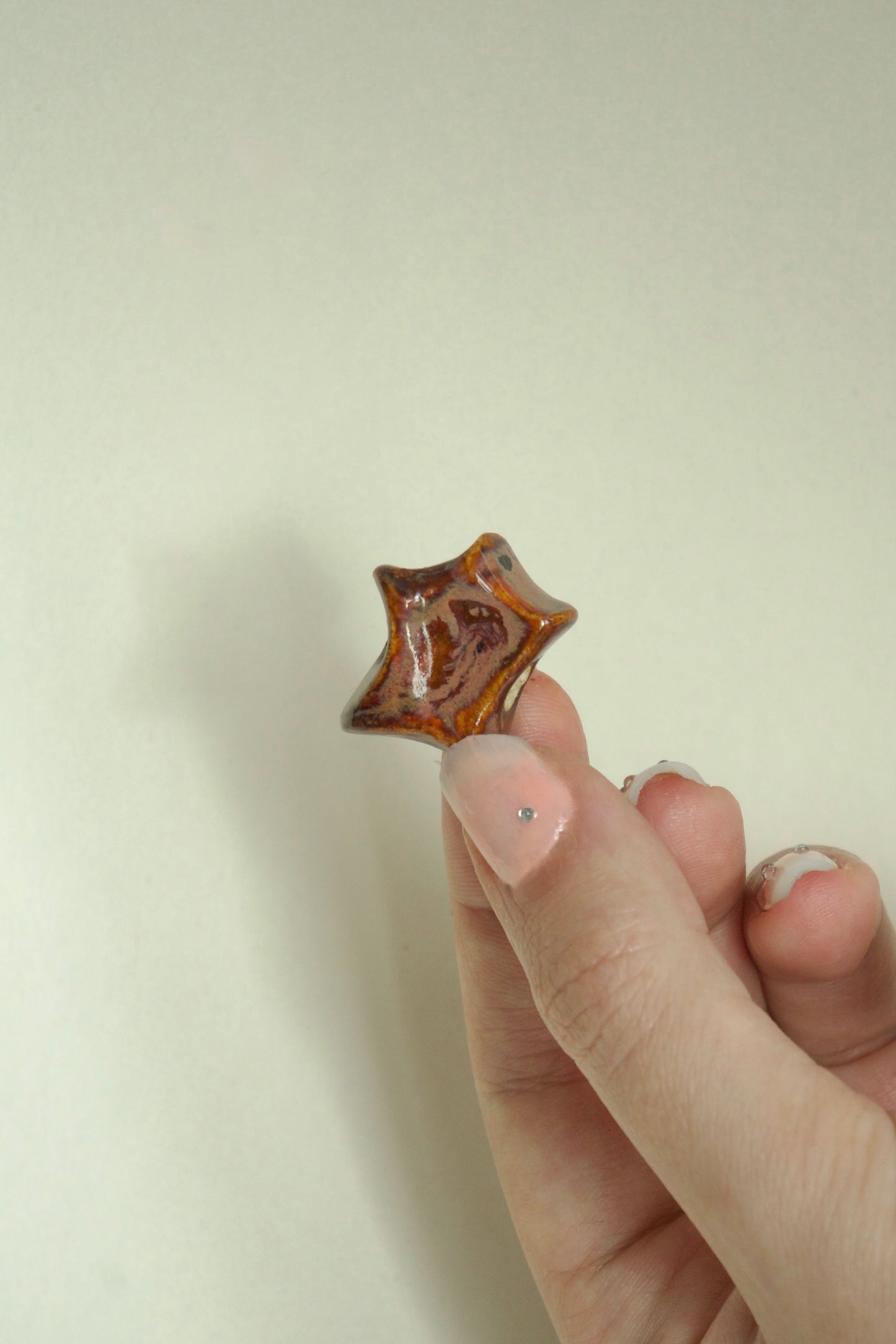 Charm ceramică organic maro cu accente negre. Produs unicat, ideal pentru coliere personalizate sau purtat singur.