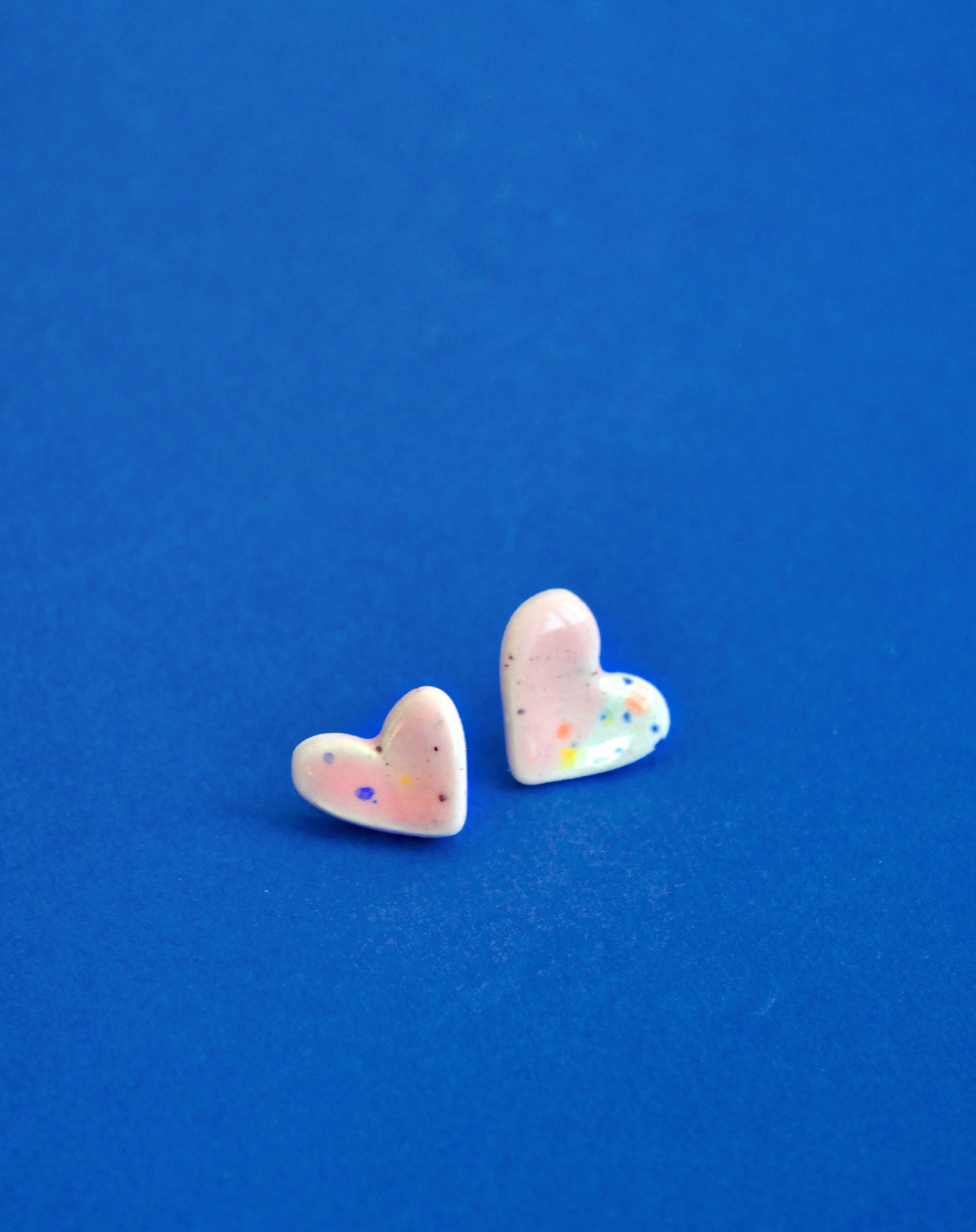 Cercei handmade din ceramică în formă de inimioare coral rosé cu accente multicolore, finisaj lucios, tije hipoalergenice.