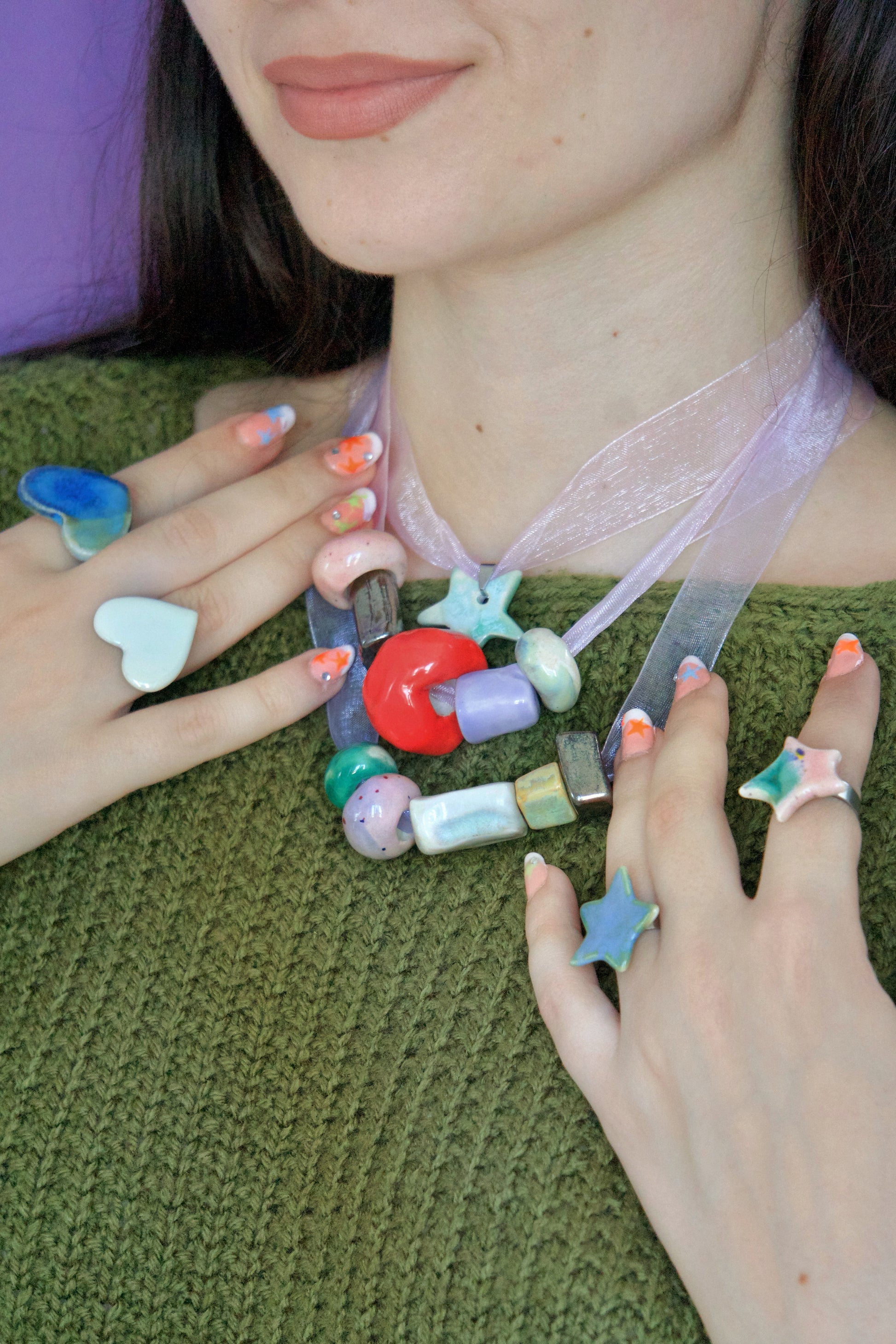 Inel handmade din porțelan, inimă alb perlat lucioasă, purtat împreună cu colier handmade din porțelan cu mărgele colorate și inele în formă de stea – bijuterii artizanale unicat.