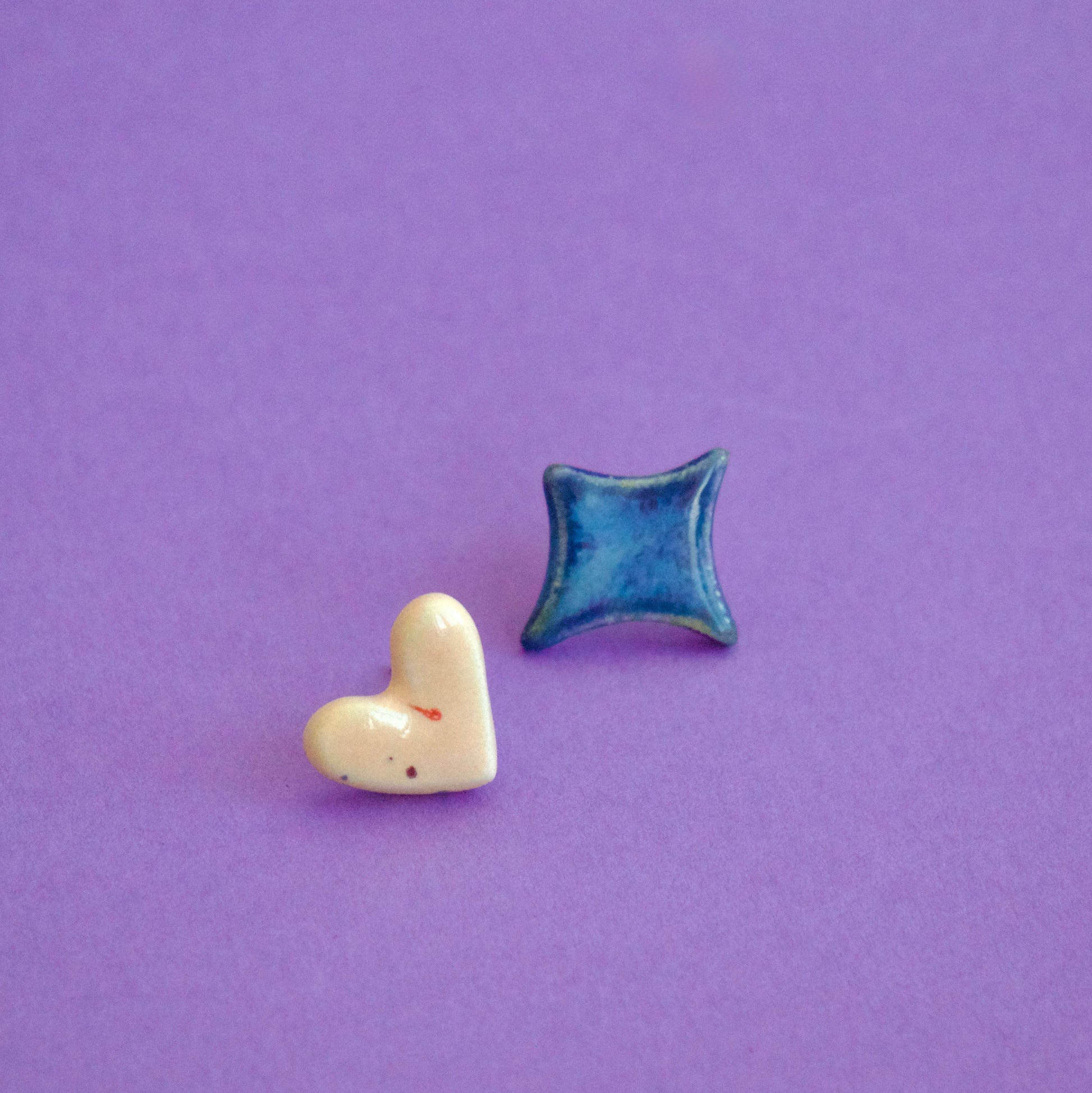 Cercei handmade asimetrici – inimă crem și romb albastru lucios, cu tije hipoalergenice.