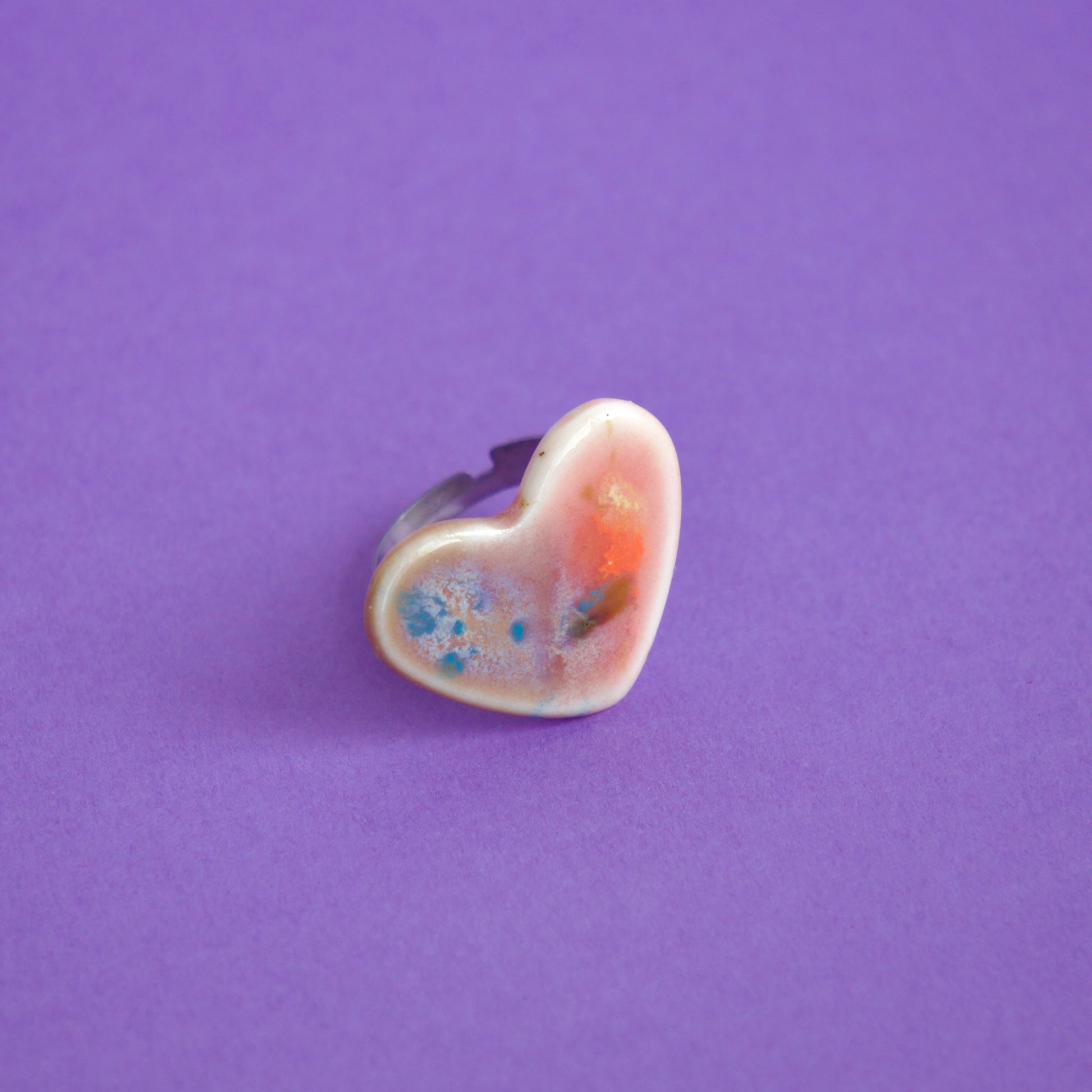 Inel handmade din porțelan, formă inimă cu glazură artistică multicoloră, pe corp ajustabil din oțel inoxidabil – bijuterie unicat.
