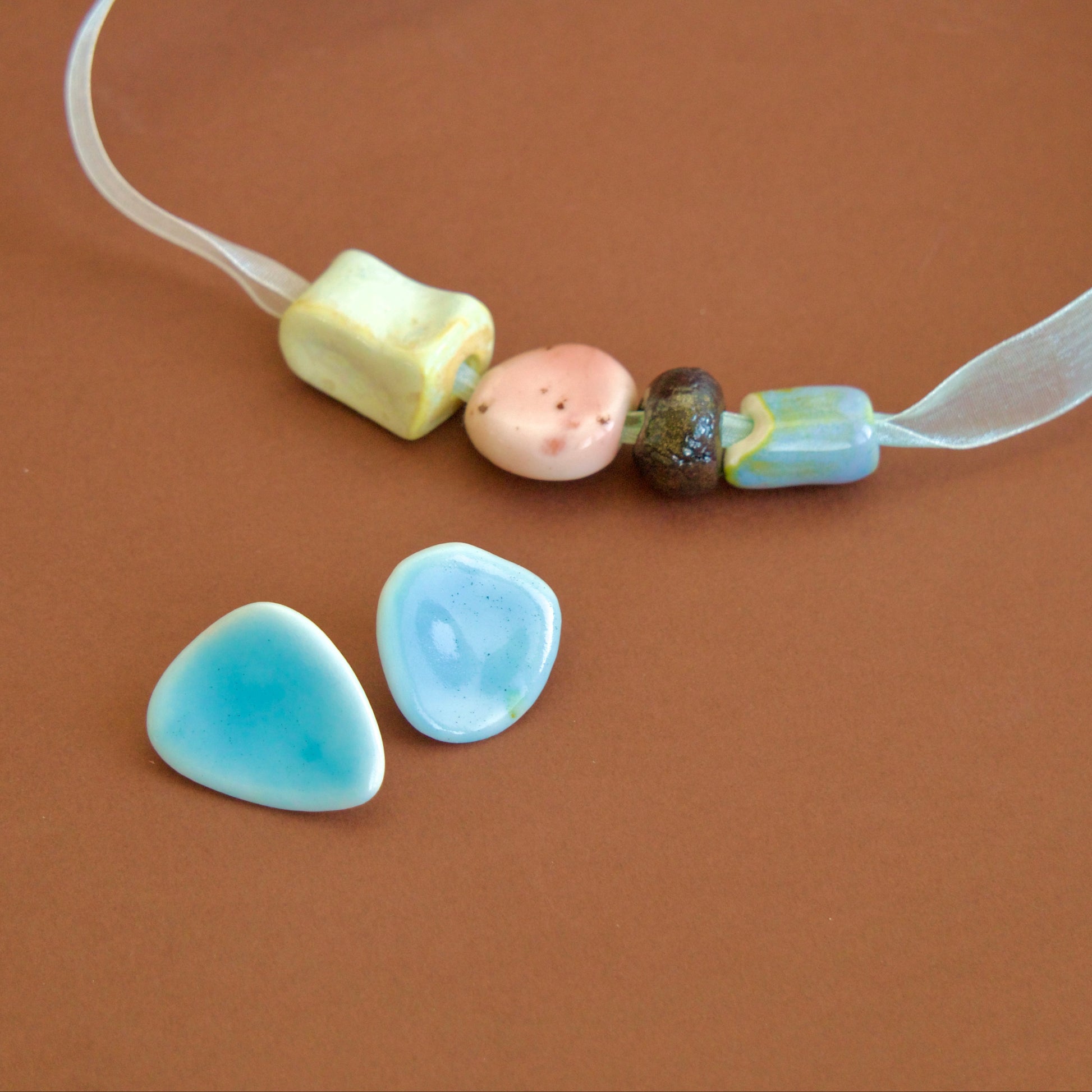 Colier handmade cu mărgele ceramice pastel (roz, crem, maro, bleu) si cercei bleu din portelan unicat. 