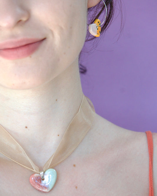 Colier unicat cu pandantiv stea roz-vleu perlat din portelan pe snur din organza bej purtat la gat impreuna cu cercei inimioare oranj. 