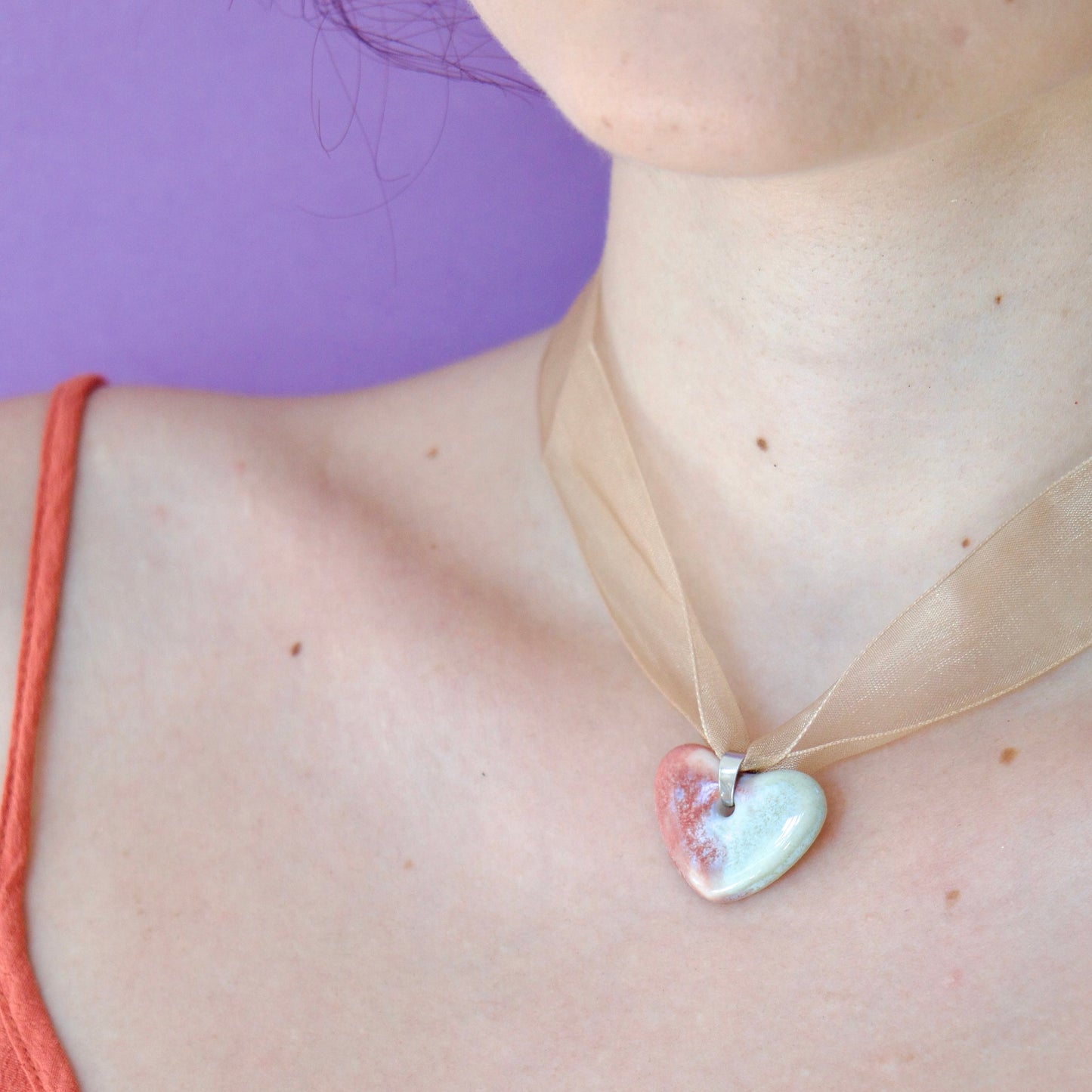 Colier unicat cu pandantiv stea roz-vleu perlat din portelan pe snur din organza bej purtat la gat.