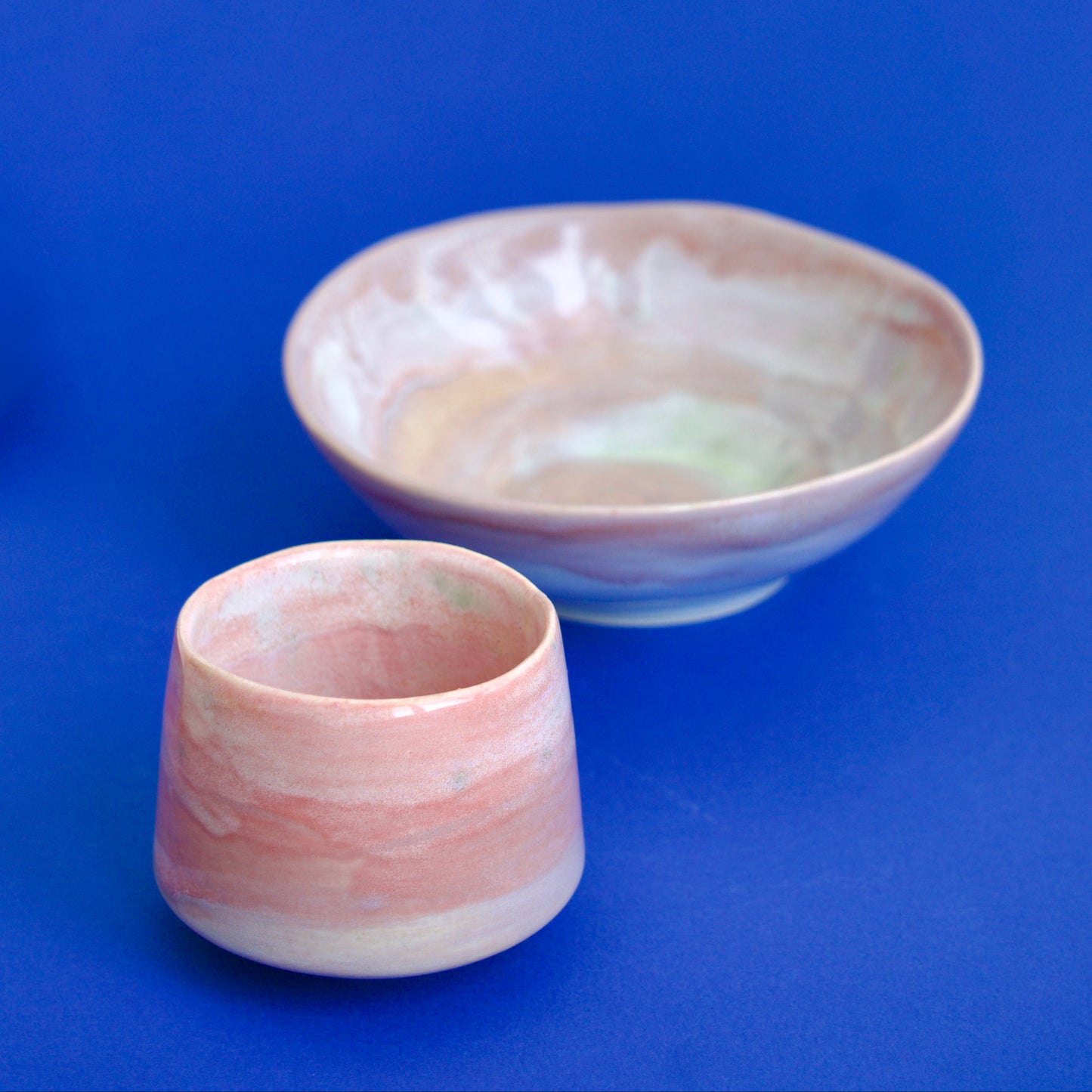 Cană espresso handmade din semi-porțelan, tonuri terracotta, alaturi de bol roz.