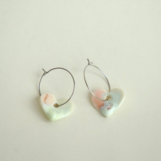 Cercei handmade din porțelan în formă de inimă, cu finisaj alb perlat și accente coral.