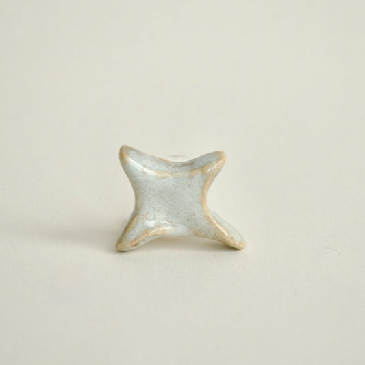 Charm handmade din ceramică în formă de stea alb perlat ideal pentru coliere personalizate pe fundal alb crem pe format patrat.