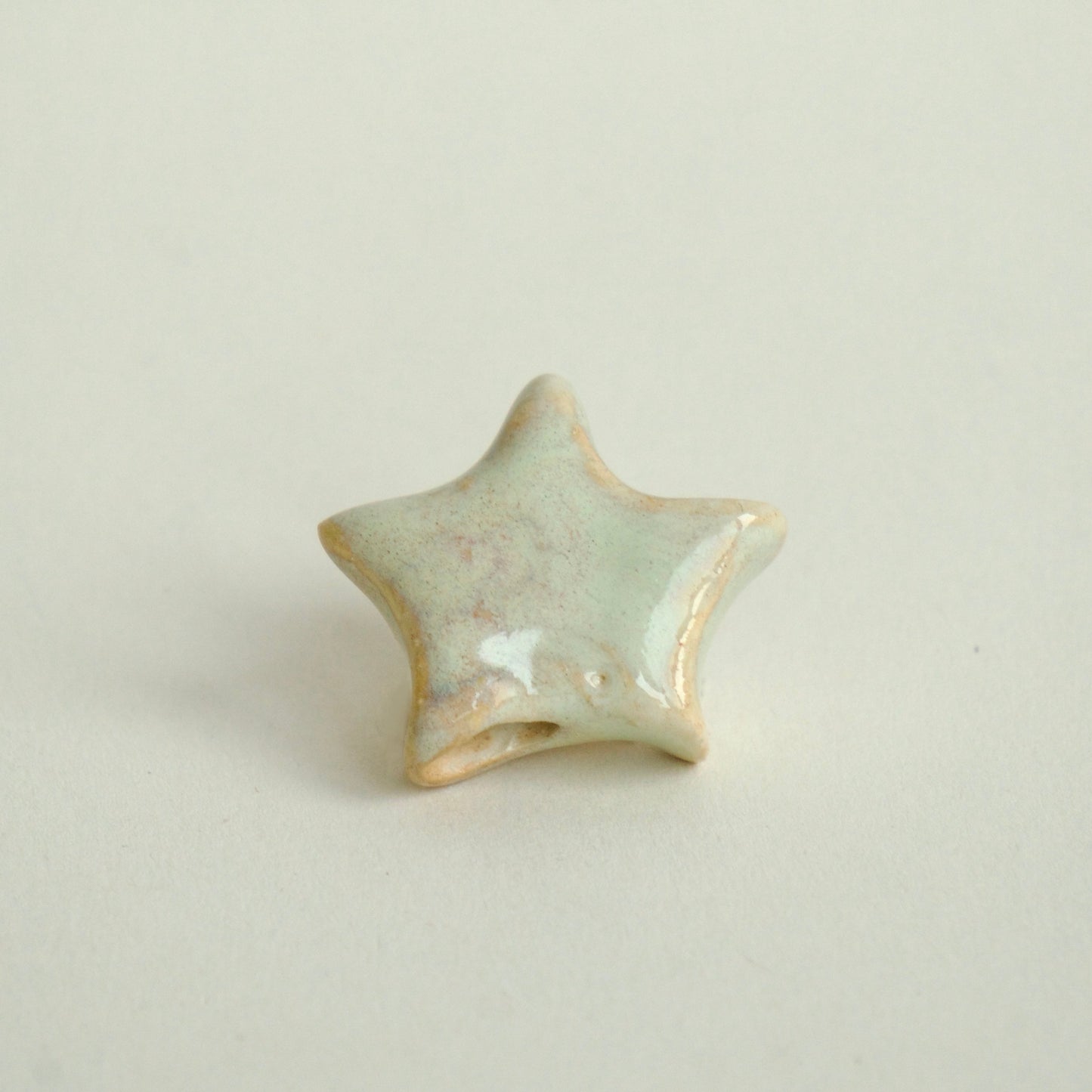 Charm handmade în formă de steluță din ceramică, alb lucios, finisaj elegant, design unicat.