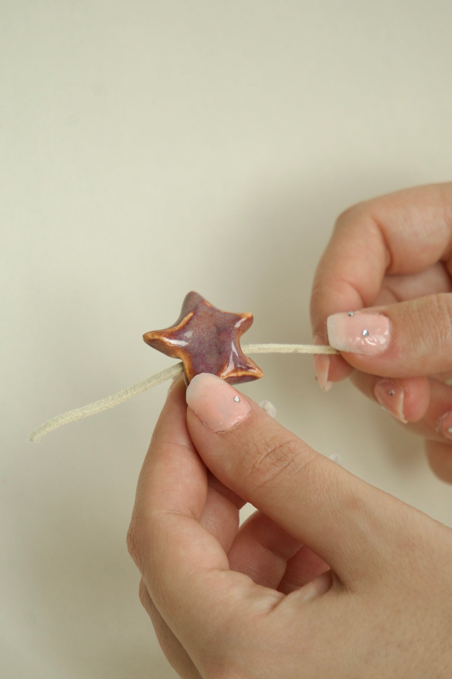 Charm handmade steluță din ceramică, nuanțe oranj și mov, prezentat în mână, produs unicat, ars la temperaturi înalte.