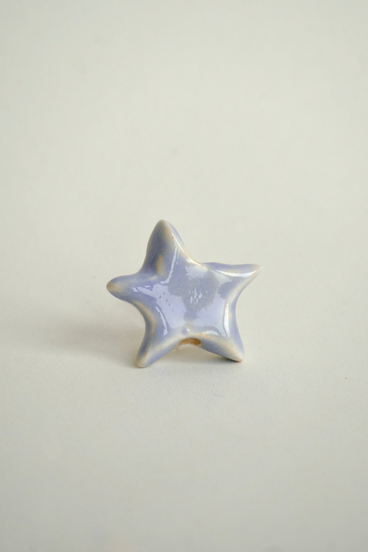 Charm lucrat manual din mase ceramice în formă de stea organică, nuanțe pastel mov-liliachiu, ideal pentru coliere personalizate. Design unic.