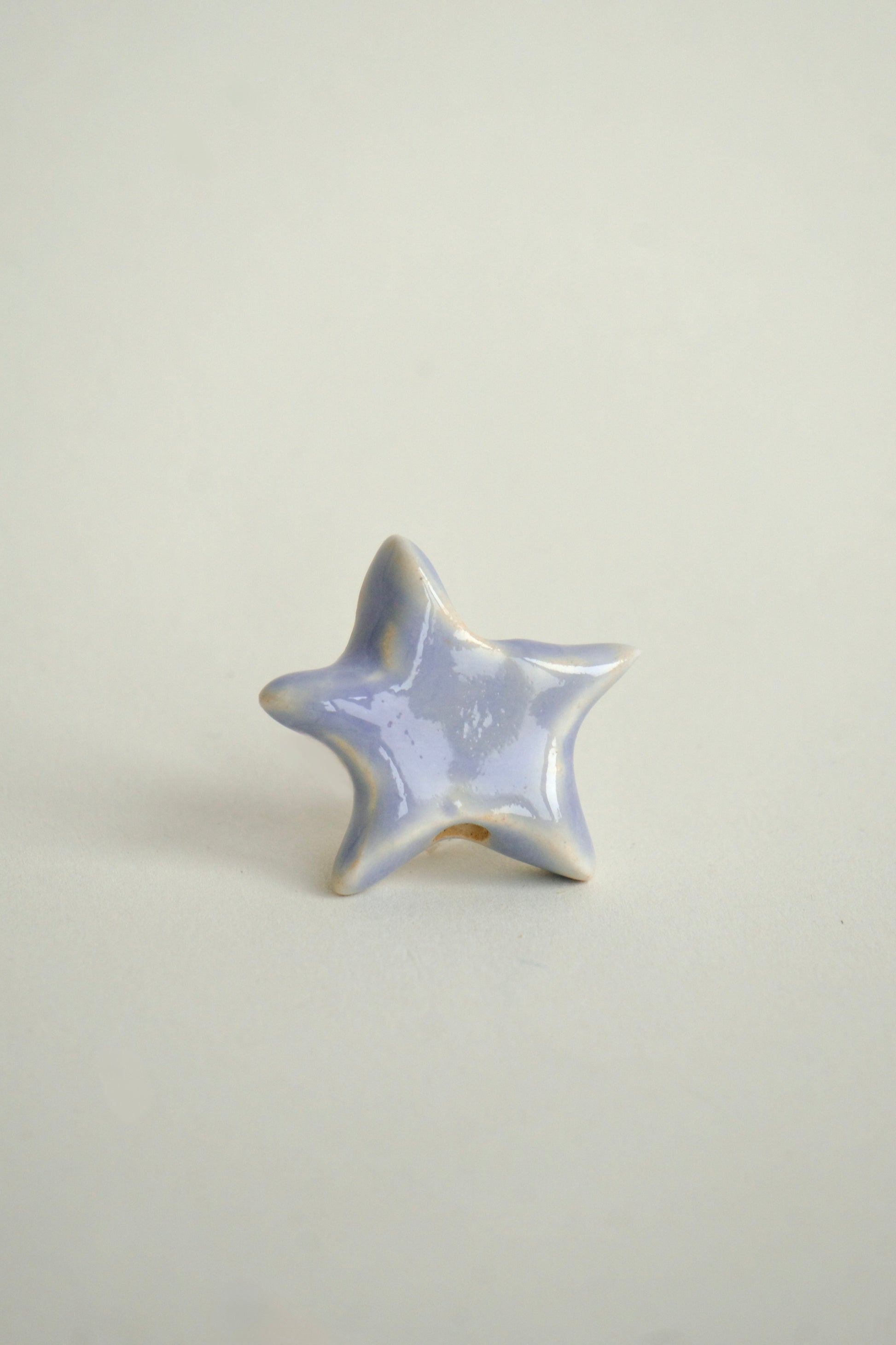 Charm lucrat manual din mase ceramice în formă de stea organică, nuanțe pastel mov-liliachiu, ideal pentru coliere personalizate. Design unic.