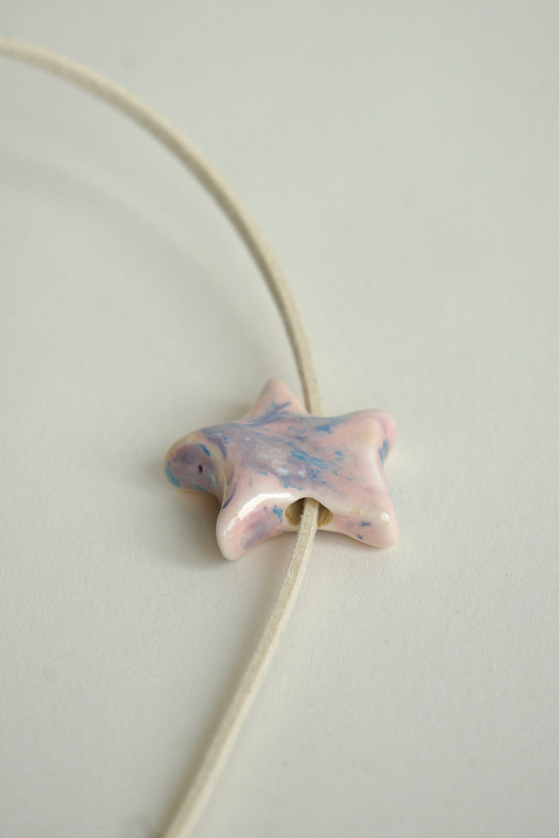 Charm handmade steluță din ceramică, roz pastel cu tonuri albastre, finisaj lucios, detaliu pe șnur.