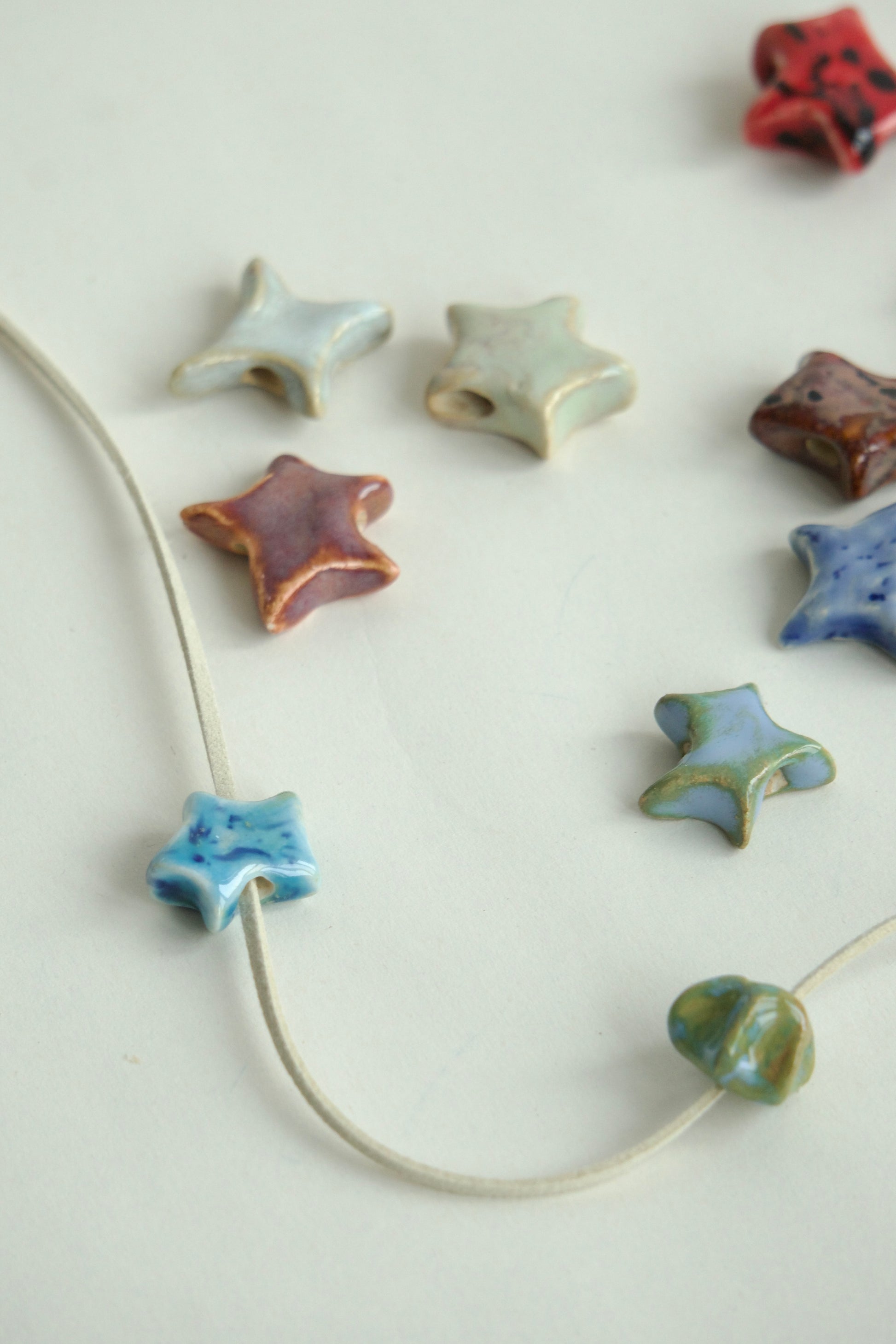 Charm ceramică handmade stea bleu pastel cu snur suede bej.Produs unicat, ideal pentru coliere personalizate sau purtat singur.