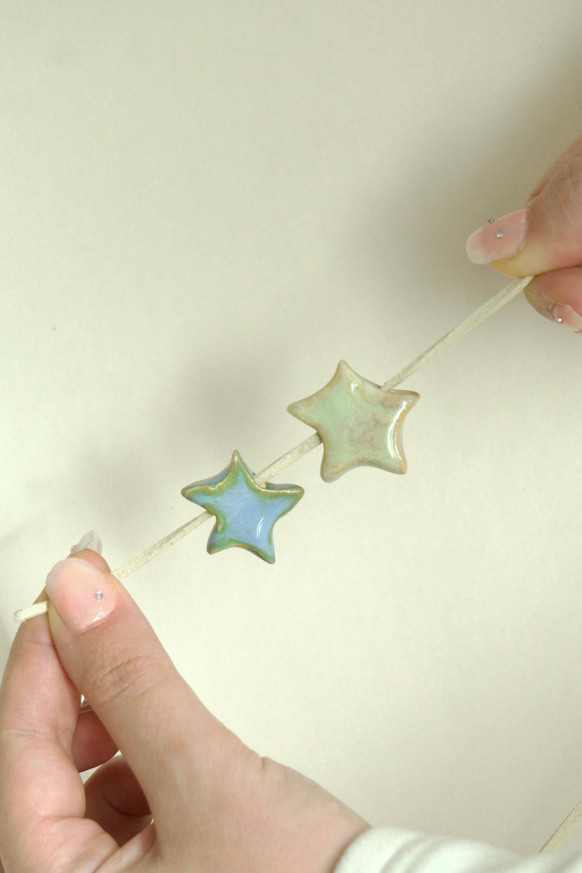 Charm ceramic stea handmade albastru pe snur din suede bej. 
